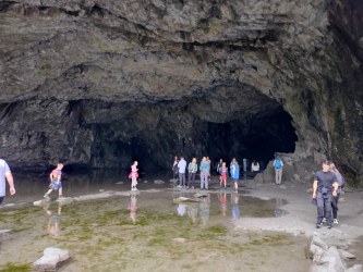 Walkers exploring the cavern of Rydal Cave near Grasmere
